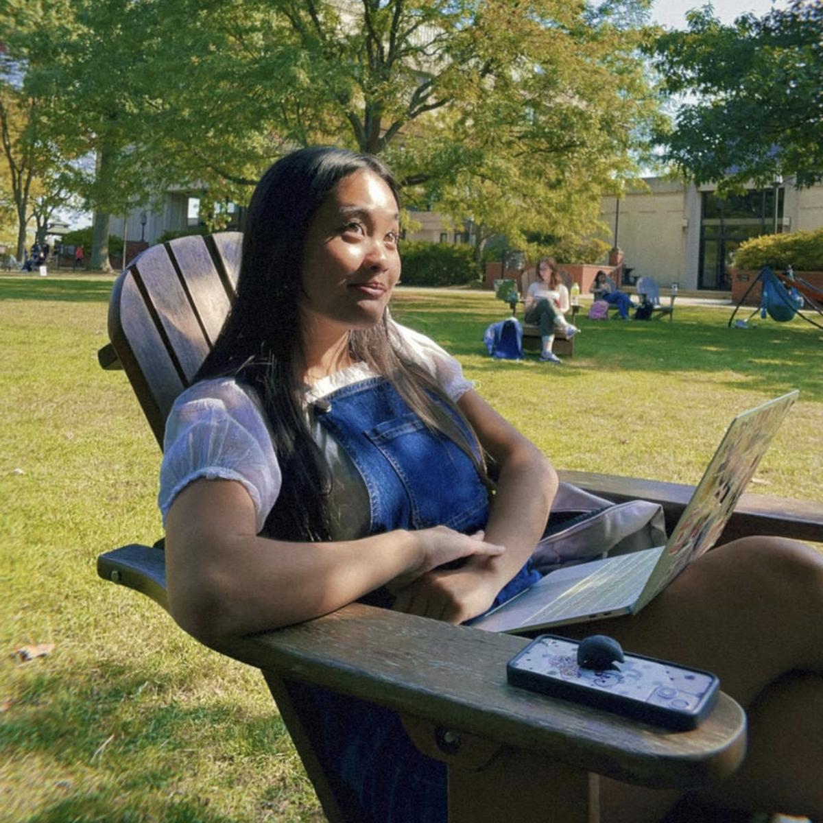 Jolie Phan sits and smiles in an Adirondack chair on 足球外围盘官方网站's quad 