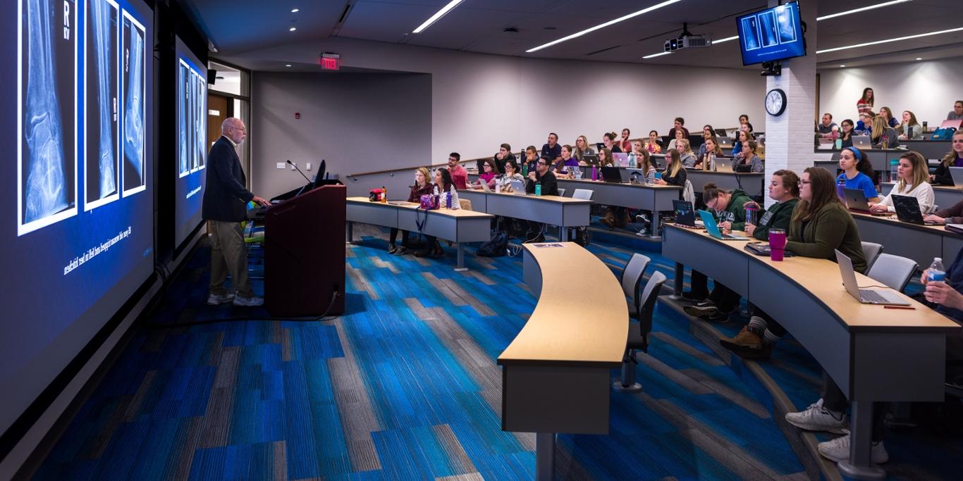 Photo of a professor teaching a classroom of 足球外围买球靠谱 students in an auditorium at the Eastside campus. 